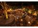 Nighttime outdoor area with lights, a fire pit, a dining table, and a unique bench around a tree at 225 Cotton Field Ct, Alpharetta, GA 30022
