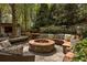 Outdoor living space with stone fire pit, built-in seating, bar, and surrounding landscape at 225 Cotton Field Ct, Alpharetta, GA 30022
