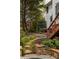 Landscaped backyard with stone pathway and steps leading to a beautiful home and deck at 225 Cotton Field Ct, Alpharetta, GA 30022