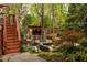 Lush backyard featuring a custom outdoor bar, fire pit, seating area, all surrounded by mature landscaping and string lights at 225 Cotton Field Ct, Alpharetta, GA 30022