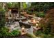Inviting backyard with outdoor kitchen, bar, fire pit, seating, and mature trees with string lights at 225 Cotton Field Ct, Alpharetta, GA 30022