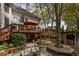 Back of house view featuring a deck with outdoor seating, a bar, fire pit, and lush greenery at 225 Cotton Field Ct, Alpharetta, GA 30022