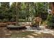 Beautiful backyard with a stone fire pit, built-in seating, a dining table, and a tree platform at 225 Cotton Field Ct, Alpharetta, GA 30022