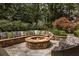 Stone fire pit and seating area with lush landscaping, making it a perfect outdoor entertaining space at 225 Cotton Field Ct, Alpharetta, GA 30022