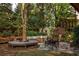 Beautiful backyard featuring string lights, a fire pit, a unique bench around a tree, and comfortable seating at 225 Cotton Field Ct, Alpharetta, GA 30022