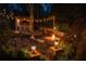 Backyard with lights, a fire pit, an outdoor bar, wood storage, seating, and beautiful landscaping at 225 Cotton Field Ct, Alpharetta, GA 30022