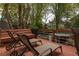 Spacious deck with lounge chairs, bench seating, and a metal railing overlooking the serene backyard and custom bar at 225 Cotton Field Ct, Alpharetta, GA 30022