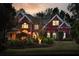Elegant brick home with manicured lawn and landscaping, illuminated by landscape lighting in the evening at 225 Cotton Field Ct, Alpharetta, GA 30022