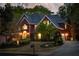 Exterior view of brick home at night featuring exterior lighting and mature trees at 225 Cotton Field Ct, Alpharetta, GA 30022