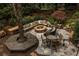 Aerial view of a custom backyard featuring a stone fire pit, built-in seating, a custom bar and lush landscaping at 225 Cotton Field Ct, Alpharetta, GA 30022