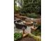 Backyard stone fire pit with built-in seating and decorative cushions, creating an inviting outdoor gathering space at 225 Cotton Field Ct, Alpharetta, GA 30022