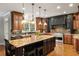 Spacious kitchen featuring dark and wood-stained cabinetry, granite counters, and a large center island at 225 Cotton Field Ct, Alpharetta, GA 30022