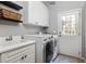 Functional laundry room with white washer and dryer, utility sink, and access to the exterior at 225 Cotton Field Ct, Alpharetta, GA 30022