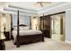 Bright main bedroom featuring a decorative four-poster bed and an ensuite bathroom with a glass shower at 225 Cotton Field Ct, Alpharetta, GA 30022
