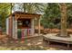 Fun outdoor bar with corrugated metal, TV, ski decor, a tree-surrounding platform, and firewood storage at 225 Cotton Field Ct, Alpharetta, GA 30022