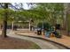 Community playground featuring a slide, climbing structures, and a covered picnic area in a wooded setting at 225 Cotton Field Ct, Alpharetta, GA 30022