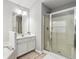 Bright bathroom featuring shower with glass enclosure, large mirror, and neutral-toned ceramic tile at 2319 White Alder Dr, Buford, GA 30519