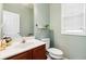 Powder room featuring tile floors, a cherry vanity with chrome fixtures, and a decorative mirror at 2319 White Alder Dr, Buford, GA 30519