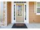 Inviting front door with glass panels, white trim, and a welcome mat on the porch at 2319 White Alder Dr, Buford, GA 30519