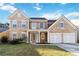Two-story home with a stone and siding exterior, two-car garage and a well-manicured front lawn at 2319 White Alder Dr, Buford, GA 30519