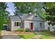 Charming home with a brick and wood exterior, red front door, stone walkway, and lush landscaping at 404 Princeton Ne Way, Atlanta, GA 30307