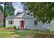 Charming home with a brick and wood exterior, red front door, stone walkway, and mature shade trees at 404 Princeton Ne Way, Atlanta, GA 30307
