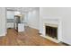 Open living space with a modern fireplace, hardwood floors, and a connected kitchen with stainless steel appliances at 404 Princeton Ne Way, Atlanta, GA 30307