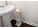 Modern half bathroom featuring pedestal sink, decorative accents, and wood flooring at 416 Blue Sky Cir, Acworth, GA 30102