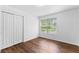 Bedroom with hardwood floors and a window overlooking the yard at 9283 Whaleys Lake Ln, Jonesboro, GA 30238