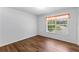 Bright bedroom featuring laminate wood flooring, a window with blinds, and neutral-colored walls at 9283 Whaleys Lake Ln, Jonesboro, GA 30238