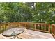 Spacious wooden deck, perfect for entertaining with glass table and beautiful views of lush greenery at 9283 Whaleys Lake Ln, Jonesboro, GA 30238