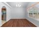Dining room featuring hardwood floors, a window with blinds, and an adjacent kitchen at 9283 Whaleys Lake Ln, Jonesboro, GA 30238
