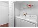 Functional laundry room with a washer, dryer, and shelving for storage at 9283 Whaleys Lake Ln, Jonesboro, GA 30238