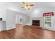 Spacious living room with a brick fireplace, light-filled windows, and beautiful hardwood floors at 9283 Whaleys Lake Ln, Jonesboro, GA 30238
