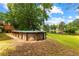 Backyard above-ground pool, set against a backdrop of lush greenery and a serene lake at 9283 Whaleys Lake Ln, Jonesboro, GA 30238