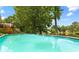 Inviting in-ground swimming pool with clear water, surrounded by lush landscaping and lake views at 9283 Whaleys Lake Ln, Jonesboro, GA 30238