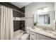 Bathroom featuring a granite countertop, shower with dark tiling, and a large mirror at 1450 Oglethorpe Sw Ave, Atlanta, GA 30310