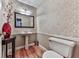 Stylish powder room features patterned wallpaper, pedestal sink, decorative mirror, and hardwood floors at 2311 October Nw Ct, Acworth, GA 30102