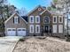 Charming two-story home with stone accents, two-car garage, and manicured front yard at 2311 October Nw Ct, Acworth, GA 30102