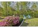 Landscaped backyard showcases a tranquil seating area surrounded by lush greenery and flowering bushes at 5035 Castlegate Ct, Cumming, GA 30040