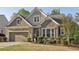 Charming home with a two-car garage, stone accents, and well-maintained landscaping at 5035 Castlegate Ct, Cumming, GA 30040