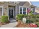 Inviting front entryway with a black door, decorative wreath, and lush greenery at 5035 Castlegate Ct, Cumming, GA 30040