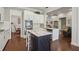 Well-lit kitchen boasts white cabinetry, stainless appliances, and stylish dark-wood island at 5035 Castlegate Ct, Cumming, GA 30040