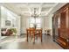 Bright dining room features dark hardwood floors, a coffered ceiling, and a chandelier at 5390 Chestnut Dr, Cumming, GA 30040