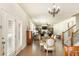 Open-concept dining room with hardwood floors, elegant chandelier, and access to the living area and staircase at 5390 Chestnut Dr, Cumming, GA 30040