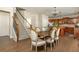Bright dining area with hardwood floors, a view of the staircase, and an open kitchen layout at 5390 Chestnut Dr, Cumming, GA 30040