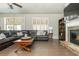 Comfortable living room with hardwood floors, a stone fireplace, and a large leather sectional at 5390 Chestnut Dr, Cumming, GA 30040