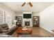 Inviting living room featuring hardwood floors, a stone fireplace, and a comfortable leather sofa at 5390 Chestnut Dr, Cumming, GA 30040