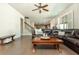 Spacious living room featuring hardwood floors, a comfortable leather sectional, and a view of the staircase at 5390 Chestnut Dr, Cumming, GA 30040