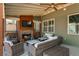 Inviting outdoor space with a stone fireplace, seating, and a mounted television at 5390 Chestnut Dr, Cumming, GA 30040